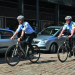 Politi på cykel så mand ryge det forkerte på en bænk