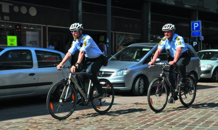 Politi på cykel så mand ryge det forkerte på en bænk